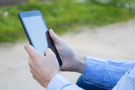 manos con la tableta digital o el ebook, closeup