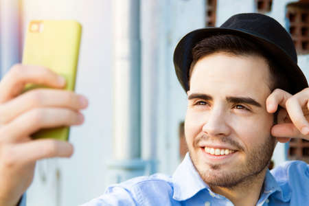 selfie, man modern hipster becoming photos with your phoneの写真素材