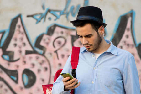 young man hipster with the phone on the street