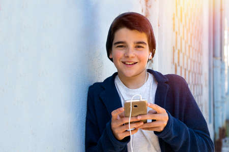 child with a mobile phone in the street about the blue wallの写真素材
