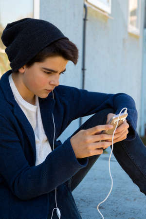 child with a mobile phone in the street about the blue wallの写真素材