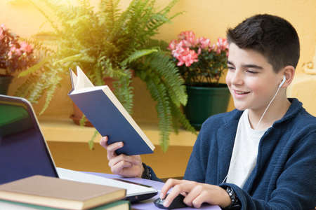 child studying with the book and the computer