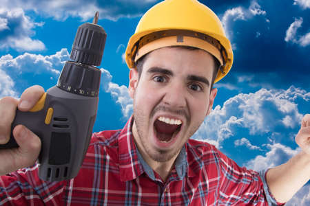 builder shouting euphoric with the drillの写真素材