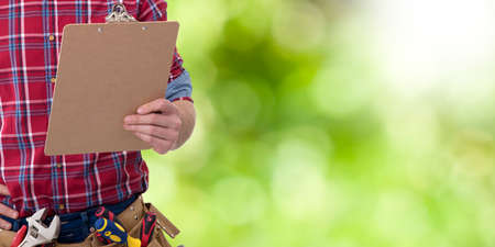 builder with a folder of documents, building repairs and maintenanceの写真素材