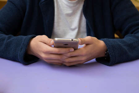 close-up of hands of the child with the mobile phone