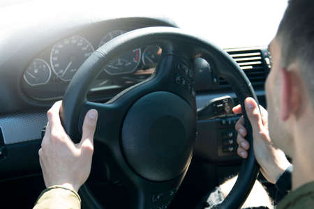 young man in the car with the steering wheel drivingの写真素材