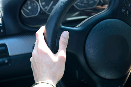 young man in the car with the steering wheel driving