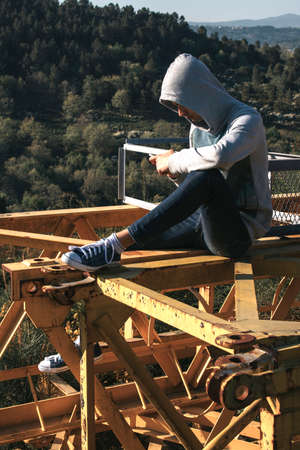 teenager with mobile phone outdoors coat with hoodの写真素材