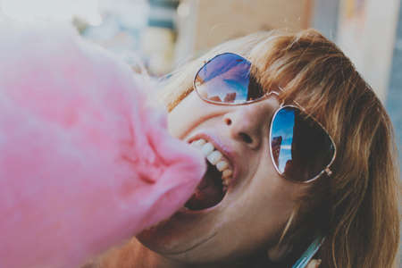 young woman with cotton candy at the partyの写真素材