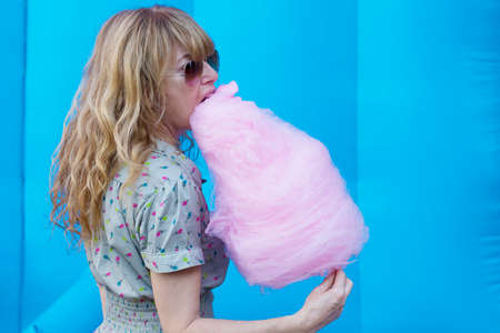 young woman with cotton candy at the partyの写真素材