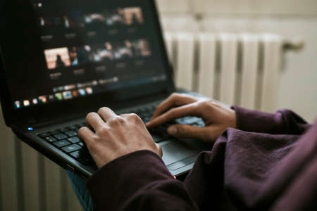 close-up of the young man with the laptop at home workingの写真素材