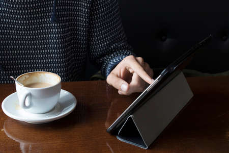 hands with mobile phone taking coffee in the cafeteriaの写真素材