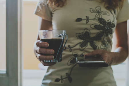 hands of woman with cup of black coffeeの写真素材