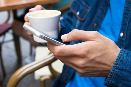 with the mobile phone in the cafeteriaの写真素材