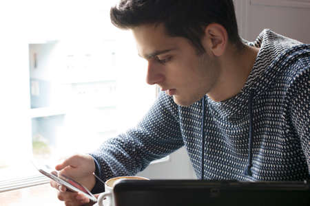 young man with mobile phone indoorの写真素材