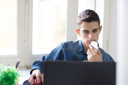 young man working with the computer laptop and mobile phoneの写真素材