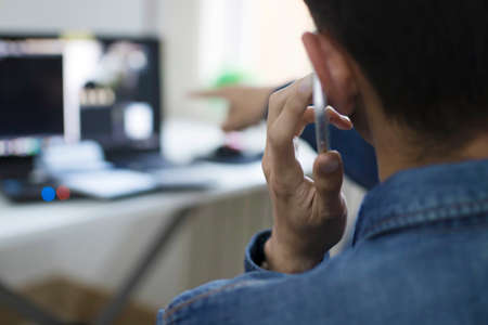 freelance speaking by phone with the computer in the officeの写真素材