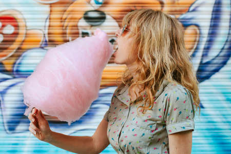 girl eating cotton candy at the amusement parkの写真素材