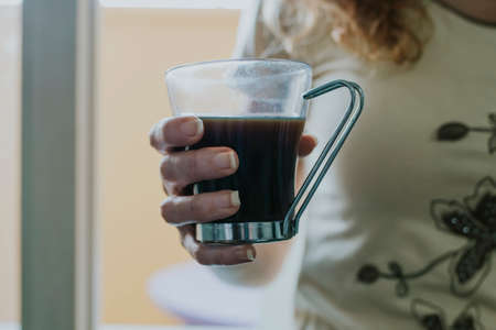 hands of woman with cup of black coffeeの写真素材