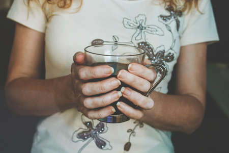 hands of woman with black coffee mugの写真素材
