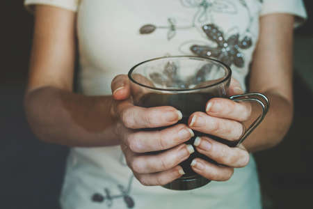 hands of woman with black coffee mugの写真素材