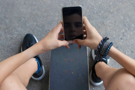 young man with the mobile phone and the skateboardの写真素材