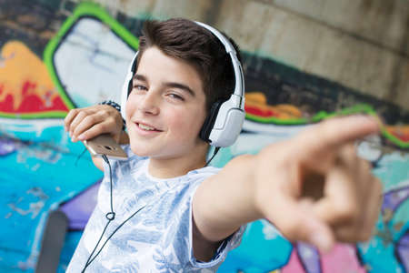child with headset and phone on the street listening to music