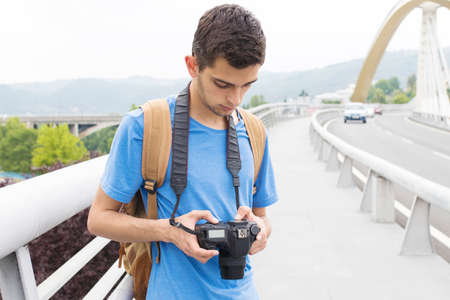 young man with the camera taking pictures in the city