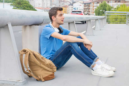 young man with headphones in the street of the city outdoorsの写真素材