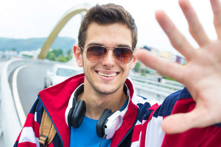 portrait of a young smiling with hand man