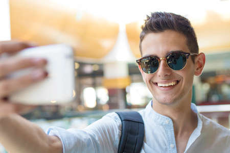 young teenager taking pictures with your mobile phoneの写真素材