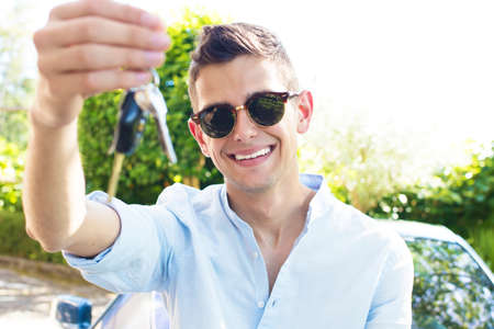 young man smiling with the car keysの写真素材