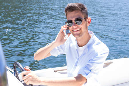 young woman talking on the phone on the yachtの写真素材