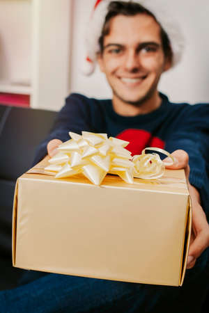 Young man at christmas with gift boxの写真素材