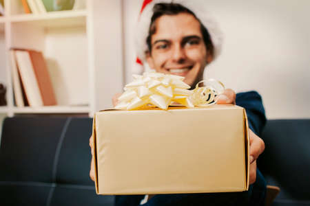 Young man at christmas with gift boxの写真素材