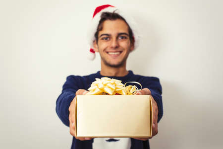 young man with clothes and christmas gift isolated in whiteの写真素材