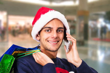 portrait of Young with christmas shopping and mobile phoneの写真素材