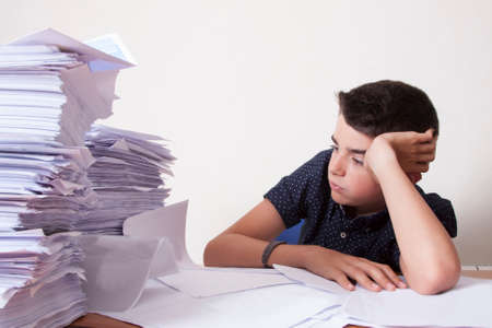 student on the desk with stacked papersの写真素材