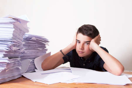 child student on the desk with stacked papers