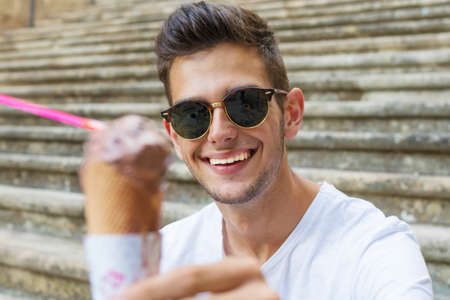teenage young man on the street with the ice creamの写真素材