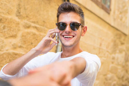 young man holding his hand talking on the phoneの写真素材