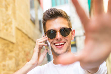 Portrait of young smiling with the mobile phone in the cityの写真素材