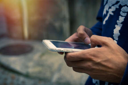 Hand with mobile phone on streetの写真素材