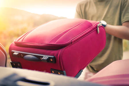 Putting the suitcase in the car boot, luggage and travel conceptの写真素材