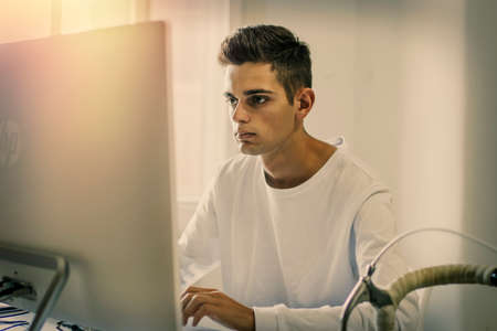 Young student using the computer at homeの写真素材