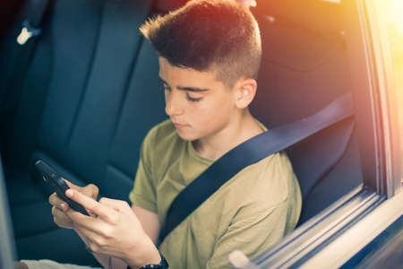 child with mobile phone in the carの写真素材