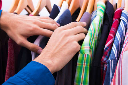 hands in the clothes shop looking at the hangersの写真素材