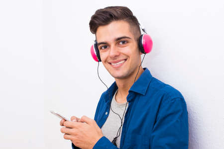 young modern teenager with phone and headphones listening to music