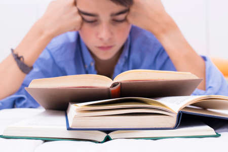 books in the foreground with young people studying, teaching and educationの写真素材