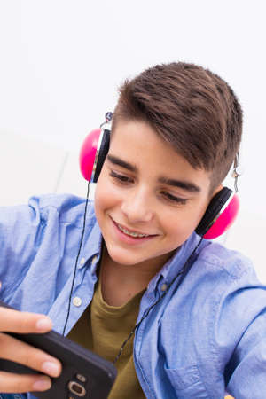 young teenager with a mobile phone listening to music or playing